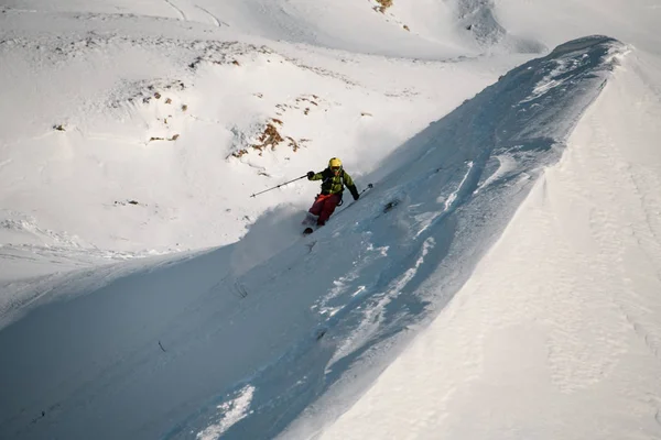 Homme skieur glisse vers le bas du sommet de la colline enneigée — Photo