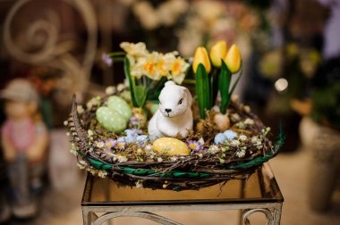 Rabbit figurine in basket with yellow tulips