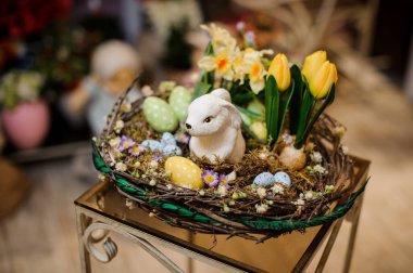 Easter rabbit in basket with yellow tulips