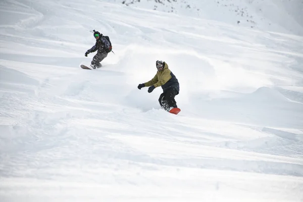 Two freeriders sliding down the mountain slope — 스톡 사진