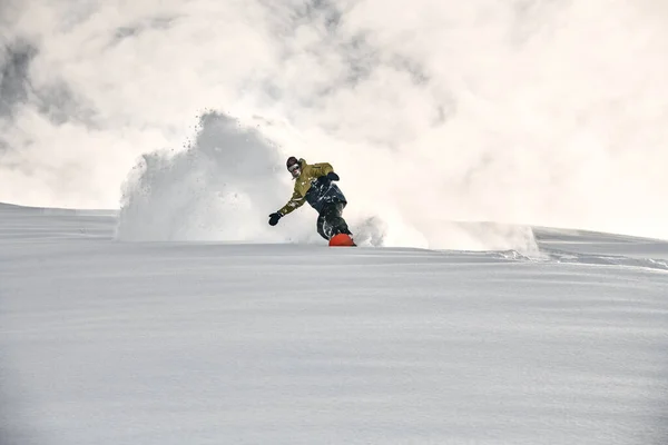 Фрирайдер на сноуборде скользит по снежной стороне горы — стоковое фото