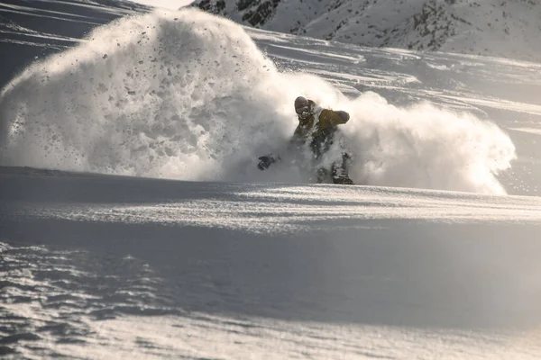 Masculino freerider com rosto coberto de neve escorregando no neve montanha — Fotografia de Stock