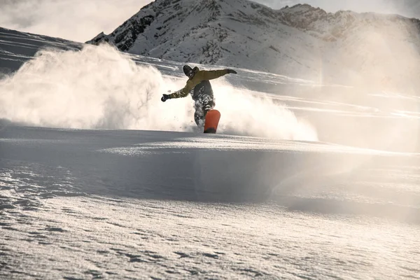 Homme snowboarder avec visage couvert de neige glissant sur montagne enneigée — Photo