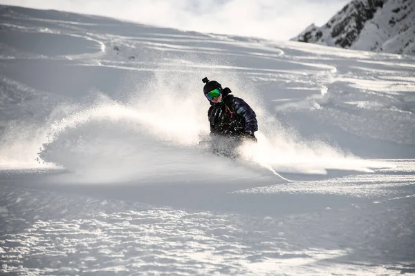 Masculino em um snowboard deslizando em uma montanha nevada — Fotografia de Stock