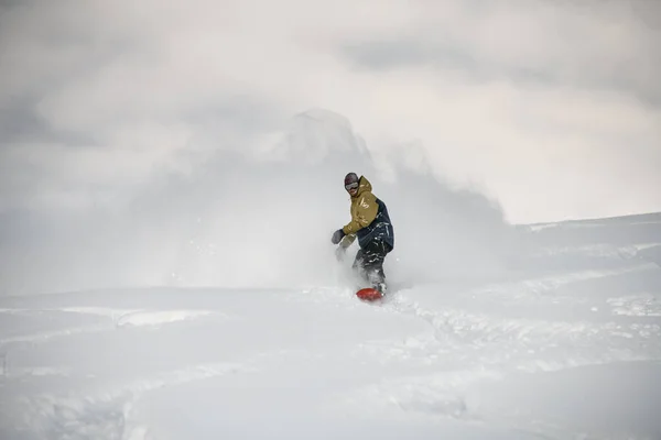 Man on a snowboard slipping on a snowy mountain — 스톡 사진