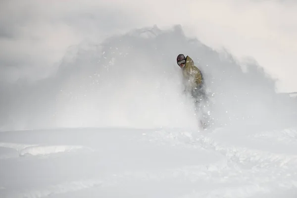 Freerider slides on a snowboard through snow cloud — 스톡 사진