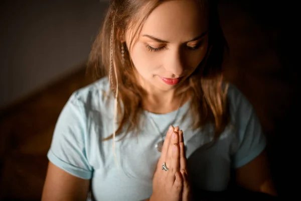 stock image Girl in sport clothes practicing yoga in a studio room in the lotus pose hold hands in namaste