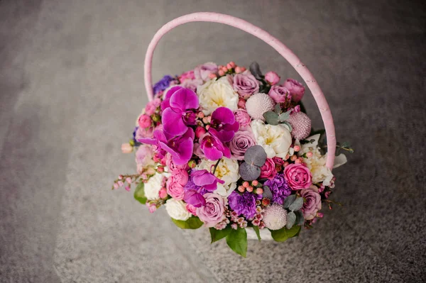 Beautiful bouquet in the basket of different variety of pink and purple flowers — 스톡 사진