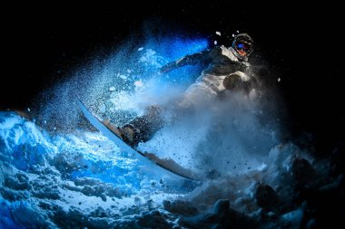 Male freerider doing stunts in night time in mountains