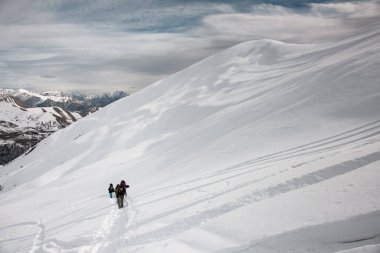 View at hikers travelling on mountain slope