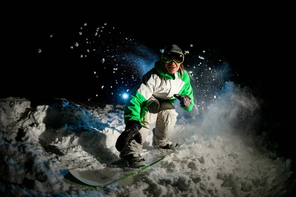 Happy male slides on a snowboard in mountains — Stok fotoğraf