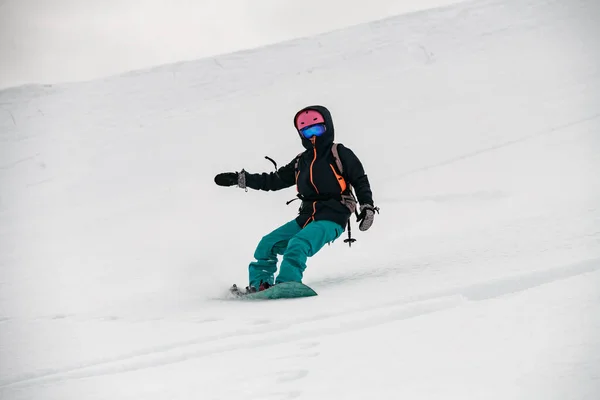 Female freerider glides down the mountain slope — Stok fotoğraf