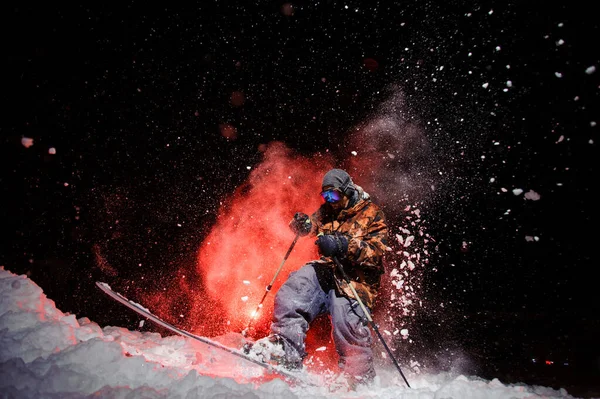 Active male skier dressed in a grey orange sportswear jumping under the snow with sticks — Zdjęcie stockowe