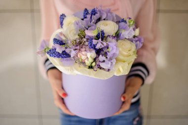 Dekoratif yuvarlak kutu, farklı çiçekler, mor tonlarda kadınlar ellerinde..