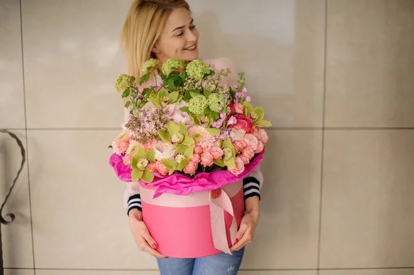 Mujer bonita sosteniendo hermosa composición con diferentes flores en caja decorativa — Foto de Stock