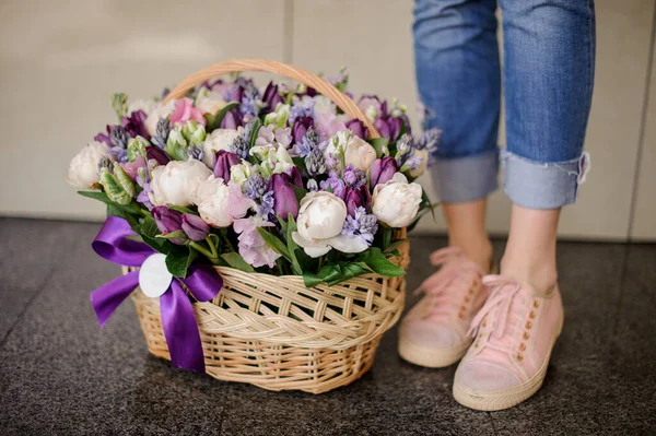Keranjang besar wicker dengan berbagai bunga musim semi dengan warna ungu . — Stok Foto