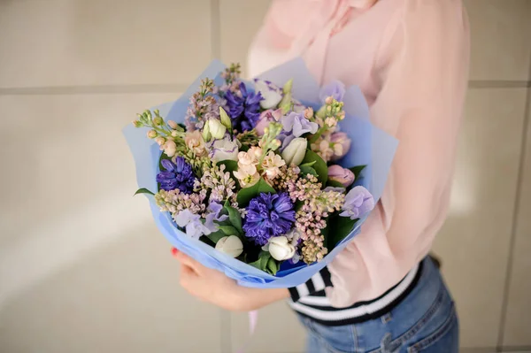ผู้หญิงที่ถือช่อดอกไม้ในสีฟ้าในมือของเธอ . — ภาพถ่ายสต็อก