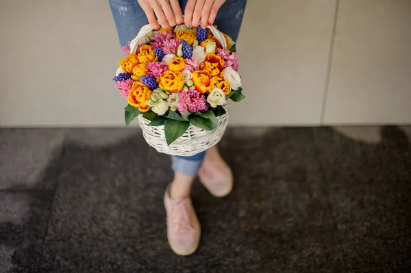 Wanita memegang keranjang dekoratif dengan bunga-bunga cerah yang berbeda . — Stok Foto