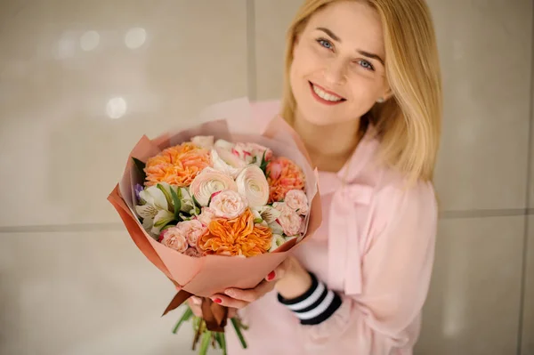 Femme souriante tenant un beau bouquet de fleurs de roses fraîches, pivoine et ranunculus . — Photo