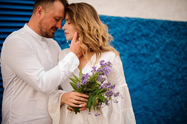 Young man hugging charming lady in white clothing — Stockfoto