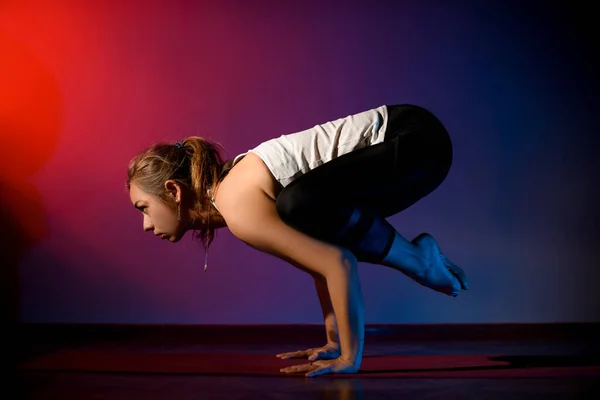 Young woman working out in studio and doing yoga pose — Stockfoto