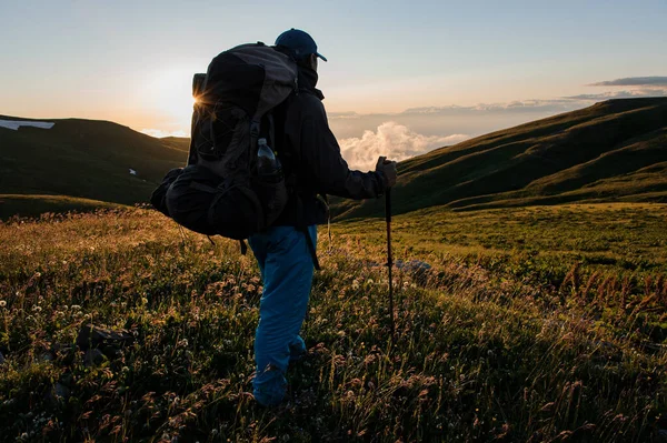 Un hombre haciendo senderismo en las montañas usando postes —  Fotos de Stock