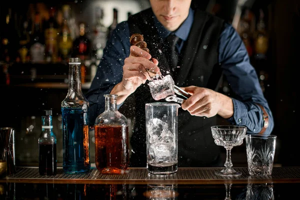 Barman con dispositivo speciale rompe pezzi di ghiaccio per fare un cocktail . — Foto Stock