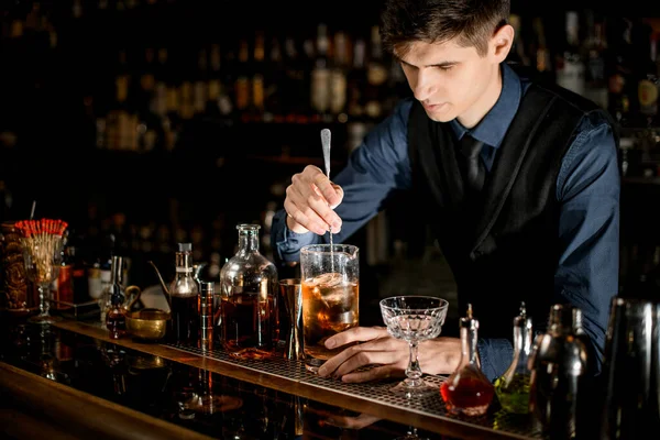 Bartender makes a cocktail over the bar counter — Stok fotoğraf