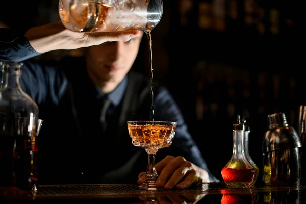Close-up como barman enche um copo de vinho com um coquetel . — Fotografia de Stock