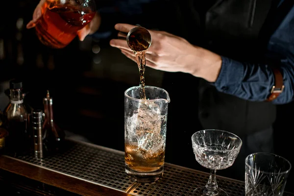Крупным планом, как бармен добавить необходимый ингредиент в стекло с коктейлем . — стоковое фото