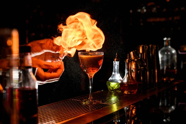 Primo piano di mani di baristi che accendono una fiamma vicino a vetro con cocktail . — Foto Stock