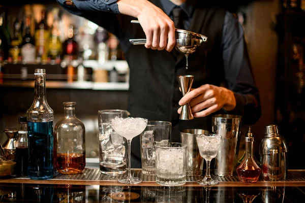 Barman profesional exprime jugo en un vaso de precipitados . — Foto de Stock