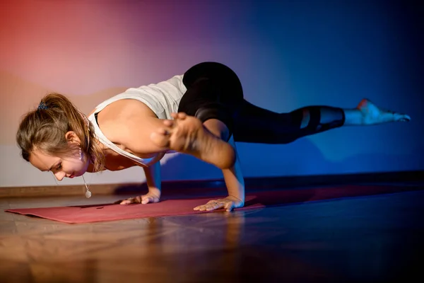 Ganska ung kvinna som tränar i studio och gör yoga pose — Stockfoto