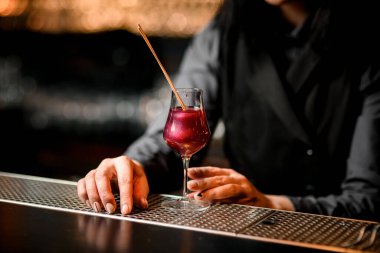 Bardakta duran iki çubukla süslenmiş pembe bir kokteyl..