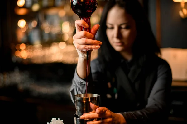 Donna barista versa bevanda alcolica marrone in shaker per fare cocktail . — Foto Stock