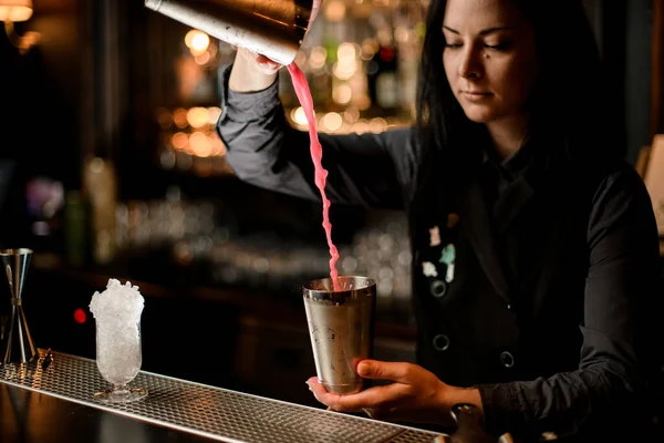 Jovem morena bartender mulher derramando coquetel usando shaker — Fotografia de Stock