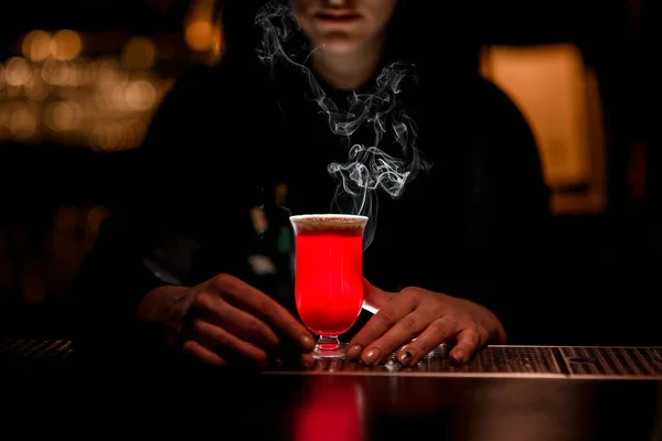 Bright red alcoholic drink standing on bar.