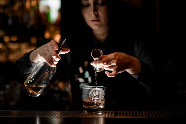 Barmen kız buzlu alkollü kokteyl hazırlıyor..