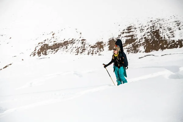 Mulher snowboarder no fundo de montanhas cobertas de neve e céu nublado . — Fotografia de Stock