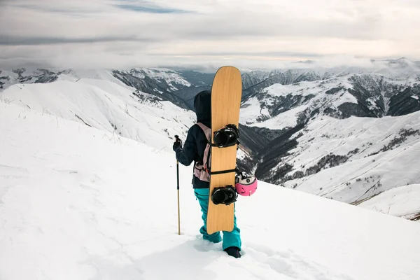 Ficar snowboarder no fundo de montanhas cobertas de neve e céu nublado . — Fotografia de Stock