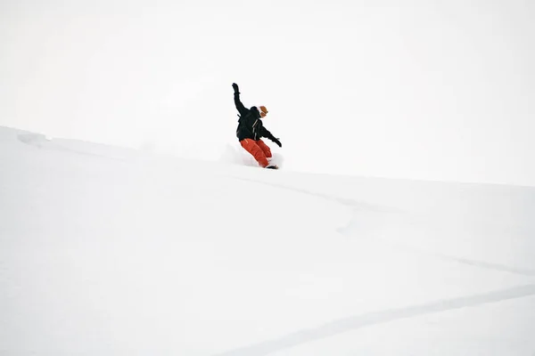 Snowboarder is riding with snowboard from powder snow hill — Stock Photo, Image