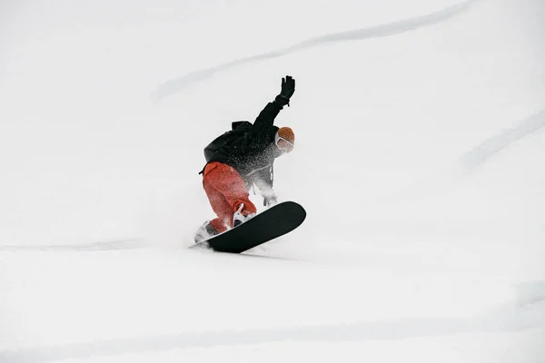 Joven activo snowboarder montar en la pendiente . —  Fotos de Stock