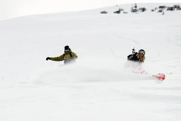 Dois snowboarders freeride desce redondamente da montanha em estilo freeride — Fotografia de Stock