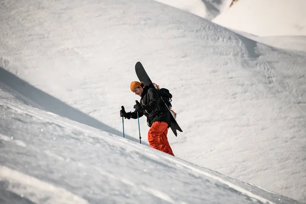 Erkek yürüyüşçü snowboard 'la dağa çıkar. — Stok fotoğraf