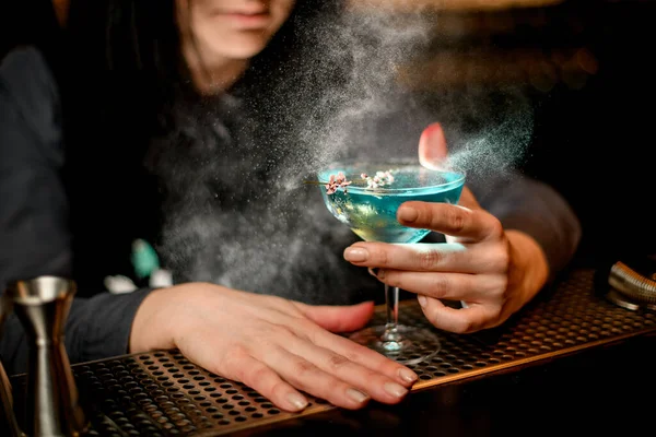 Joven morena camarera mujer sostiene vidrio con azul cóctel alcohólico —  Fotos de Stock