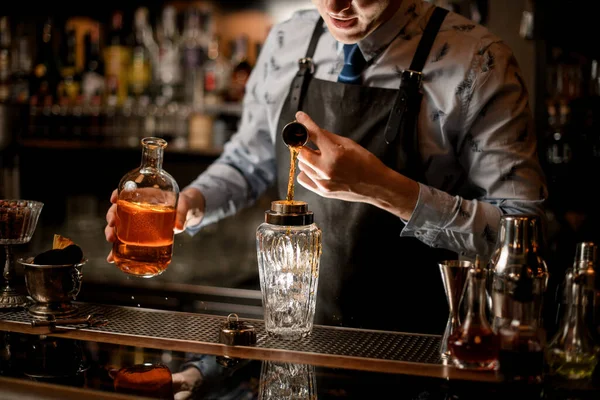 Bartender usando copo derrama bebida em copo shaker — Fotografia de Stock