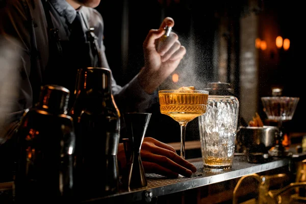 Profesjonalny spray barmanów na zimnobrązowy napój alkoholowy na ladzie. — Zdjęcie stockowe