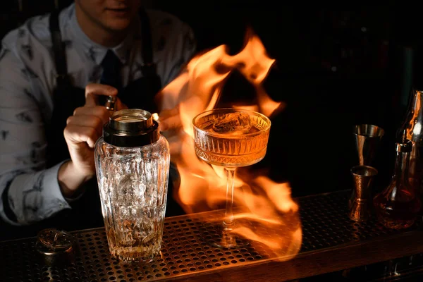 Close-up professionelle Barkeeper Spray und verbrennen kalte braune alkoholische Getränke auf der Theke. — Stockfoto