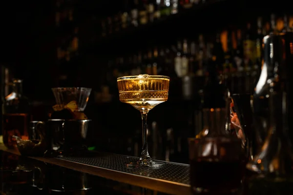 Glass of icy brown alcoholic drink stands on bar. . — Stock Photo, Image