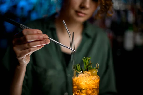 Vrouw barman versiert afgewerkte cocktail door glazen stokjes. — Stockfoto